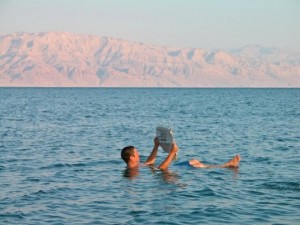 man-floating-in-dead-sea-with-newspaper-